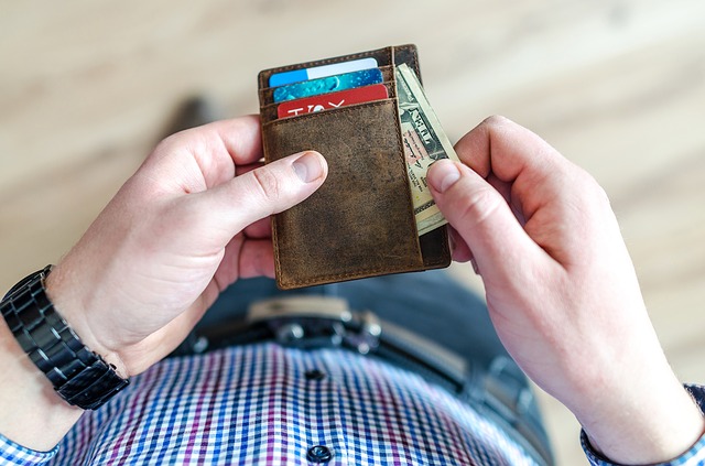 ruce držící pánskou peněženku s platebními kartami